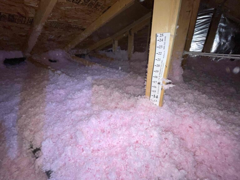 Insulation depth ruler showing new blown-in insulation at full depth