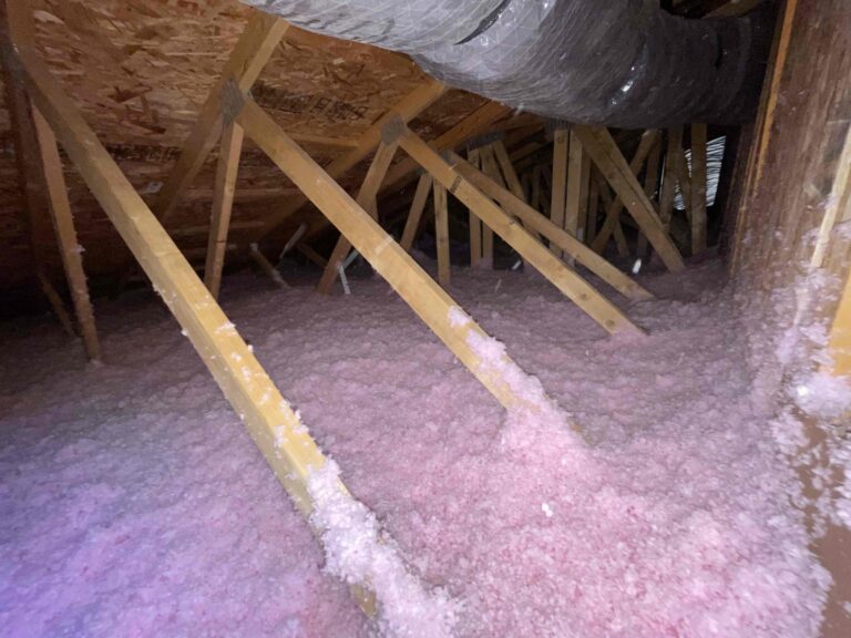 Even layer of new pink blown-in insulation across an attic