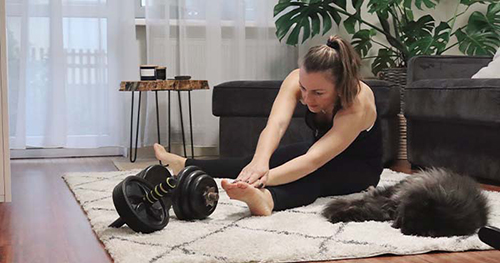 Image: A Woman And Her Cat Stretch Before Working Out.