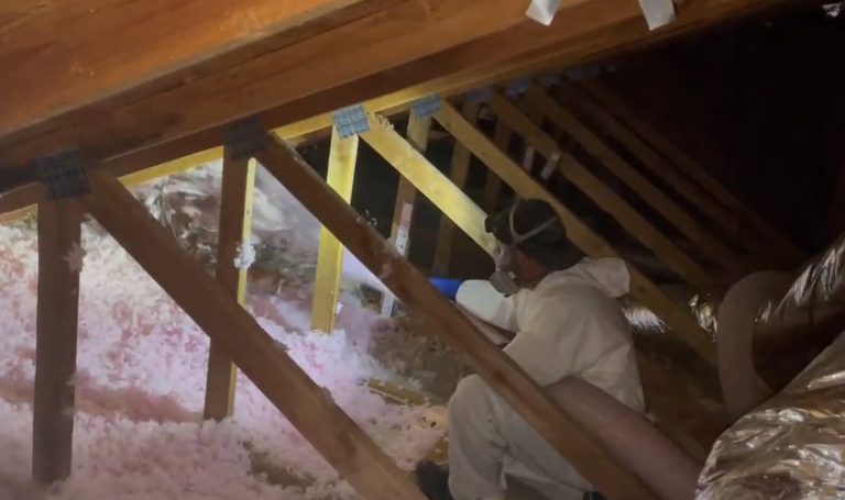 Sierra Air technician blowing new insulation into a Carson City attic